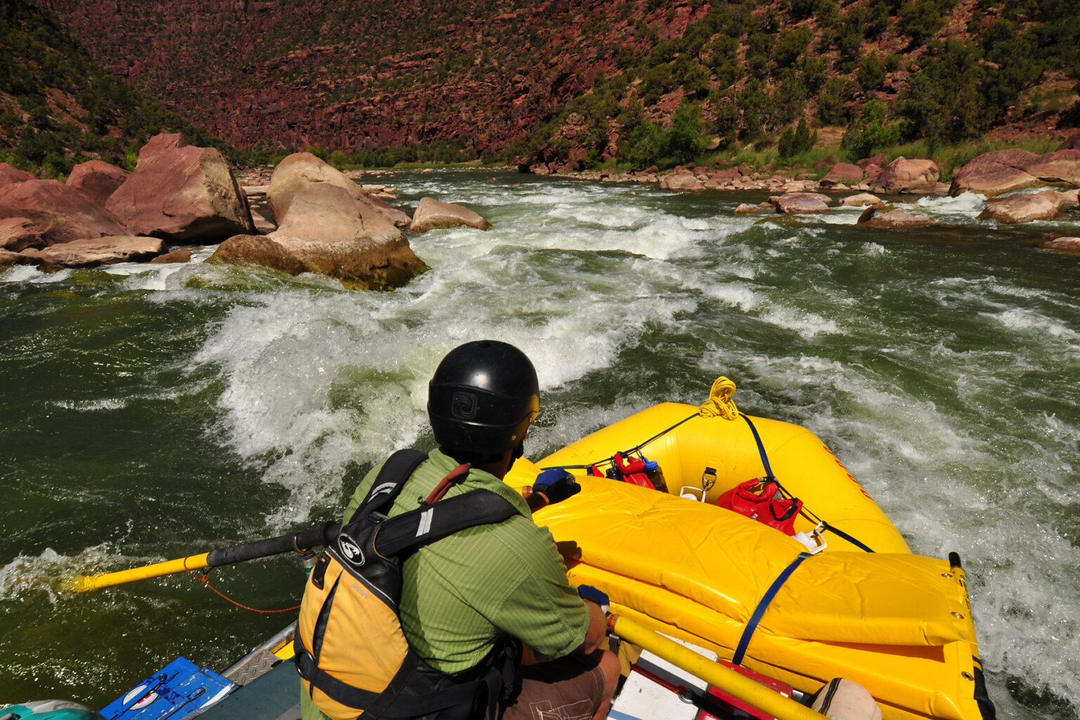 A guide rows a yellow raft through white water on the upper Green River.